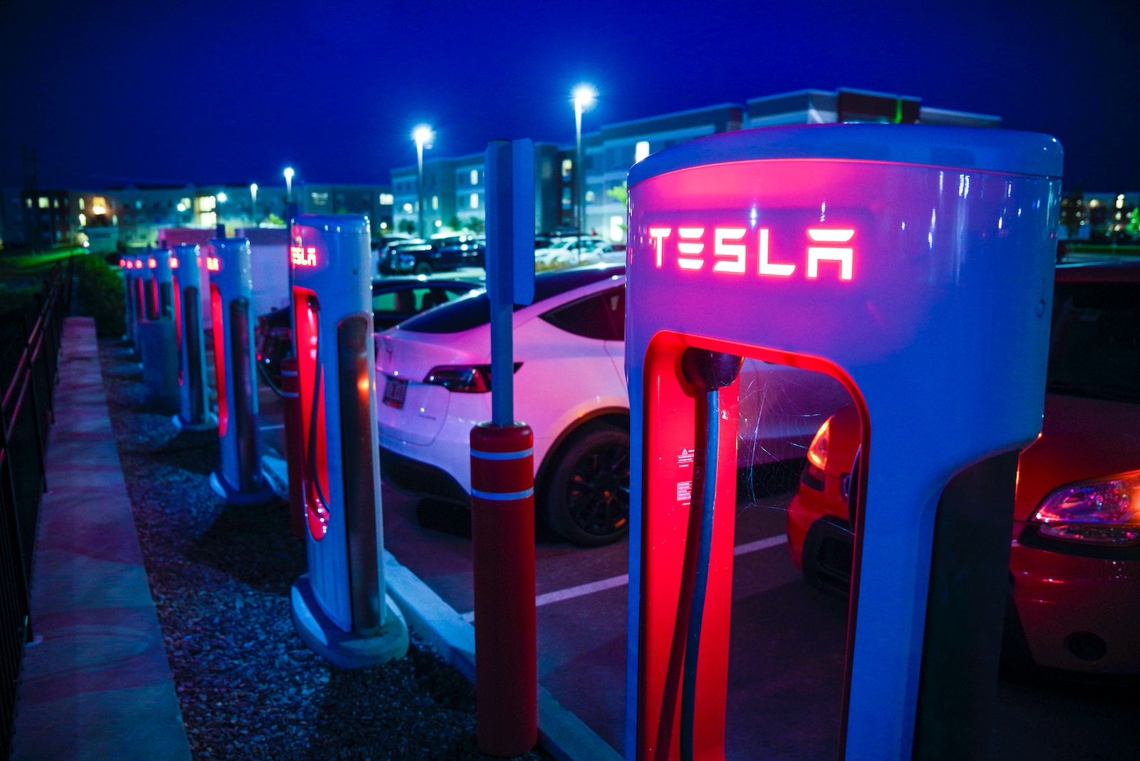 a row of tesla charging stations at night